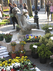 908030 Afbeelding van bloemen en planten rond het beeldhouwwerk 'Jonge Bacchus' van Mari Andriessen, op de bloemen- en ...